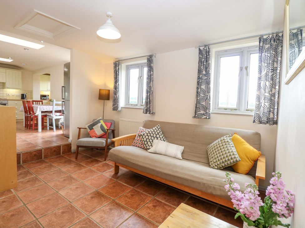 A living room with a sofa and table at Hollyhock in King's Lynn
