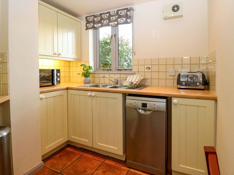 A kitchen with a sink and appliances at Hollyhock in King's Lynn