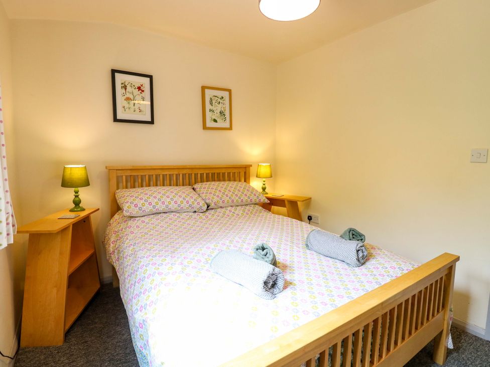 A bedroom with a bed and bedside table at Hollyhock in King's Lynn