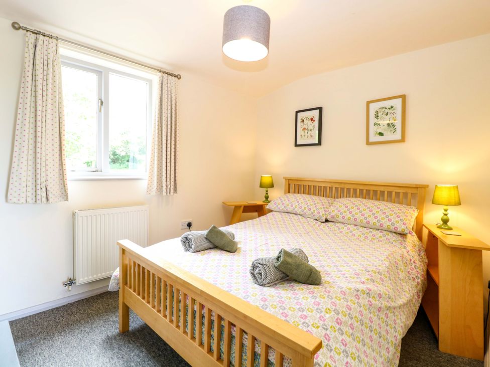 A bedroom with a bed and lamps at Hollyhock in King's Lynn