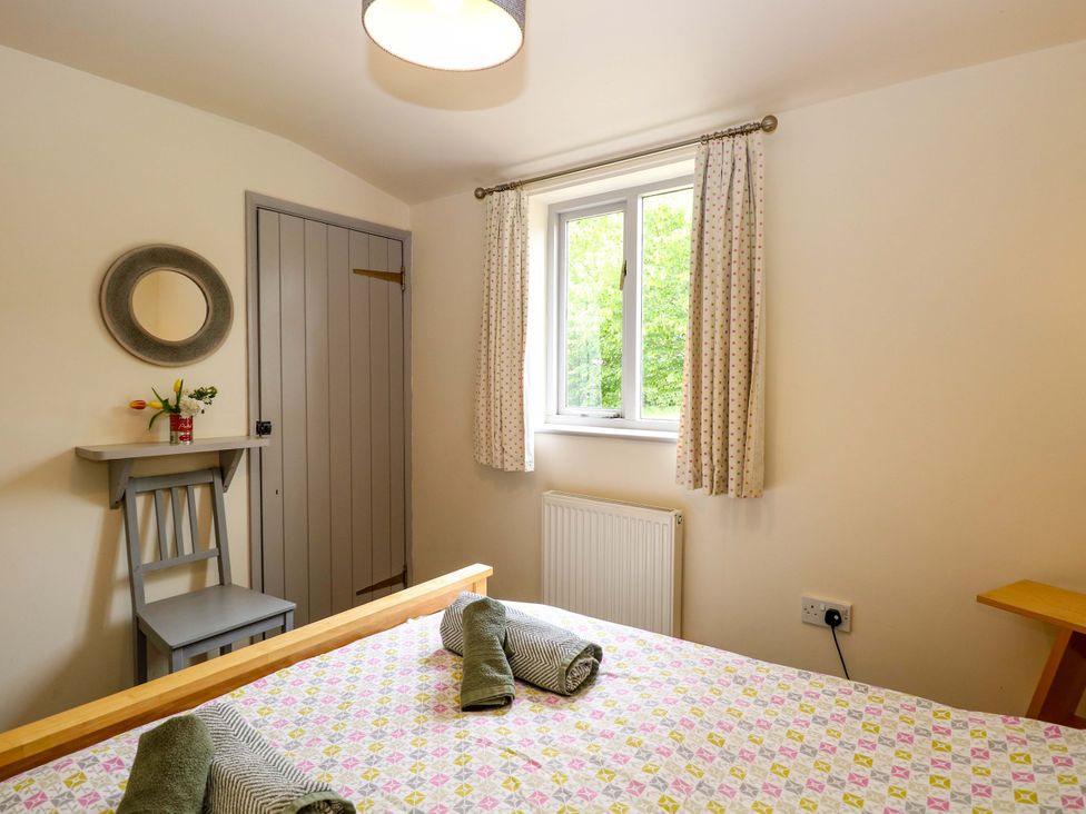 A bedroom with a bed and a chair at Hollyhock in King's Lynn