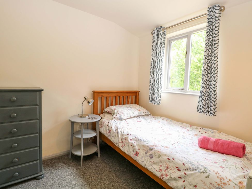 A bedroom with a bed and bedside table at Hollyhock in King's Lynn