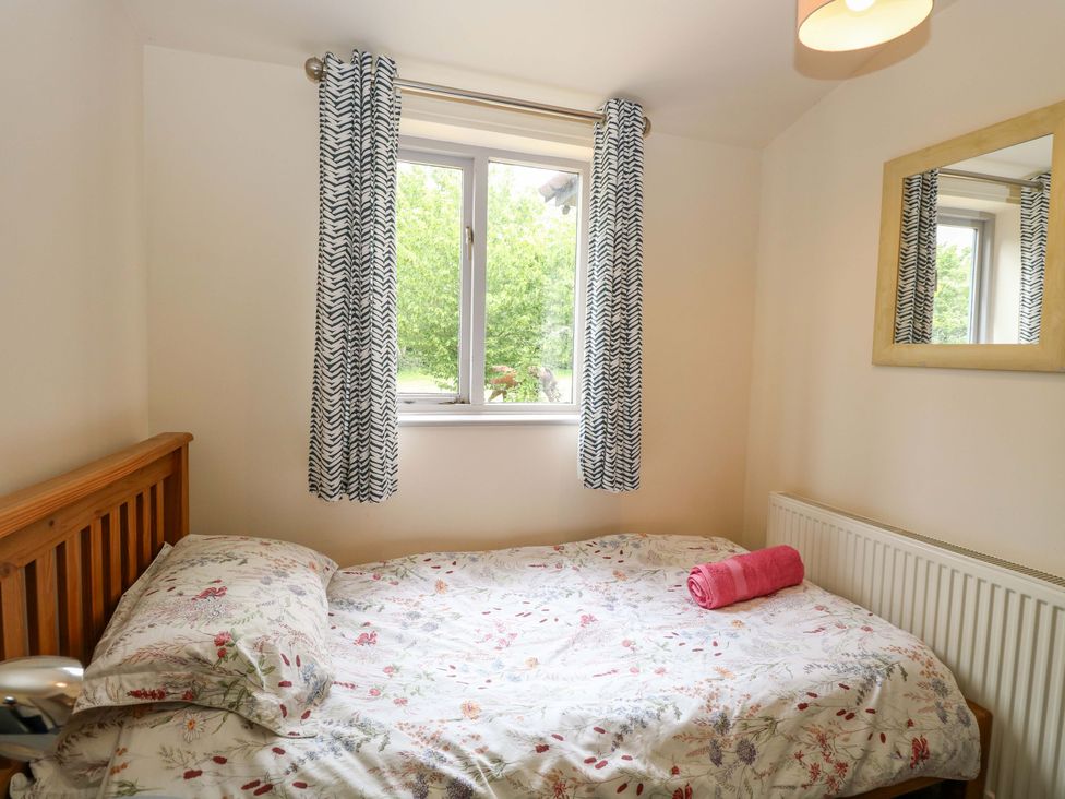 A bedroom with a bed and window at Hollyhock in King's Lynn
