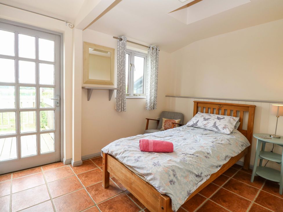 A bedroom with a bed and a window at Hollyhock in King's Lynn