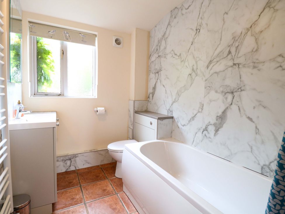 A bathroom with a bath tub and sink at Hollyhock in King's Lynn