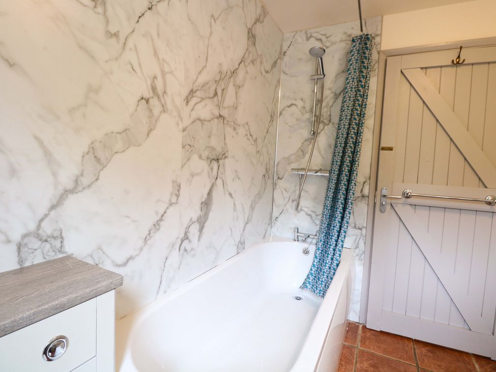 A bathroom with a bathtub and shower at Hollyhock in King's Lynn