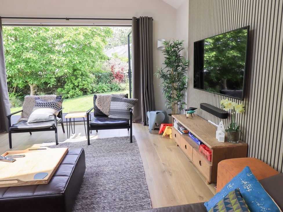 A living room with a television and seating area at Yonder Lea Bowness-On-Windermere