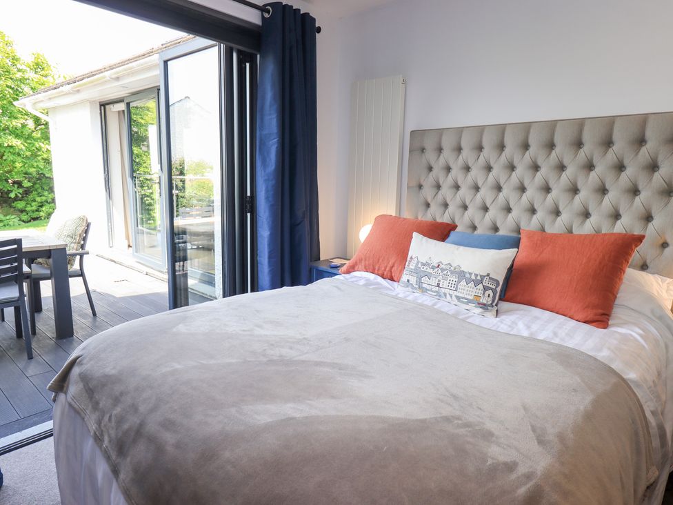 A bedroom with a bed and access to outdoor seating at Yonder Lea Bowness-On-Windermere