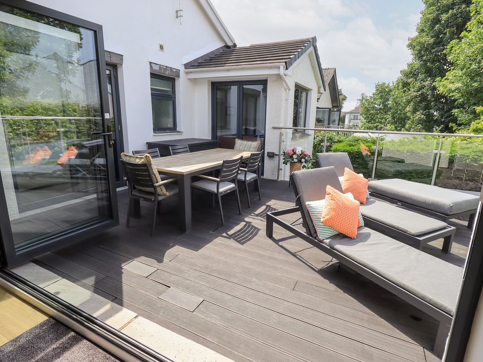 An outdoor space with a table and chairs at Yonder Lea Bowness-On-Windermere