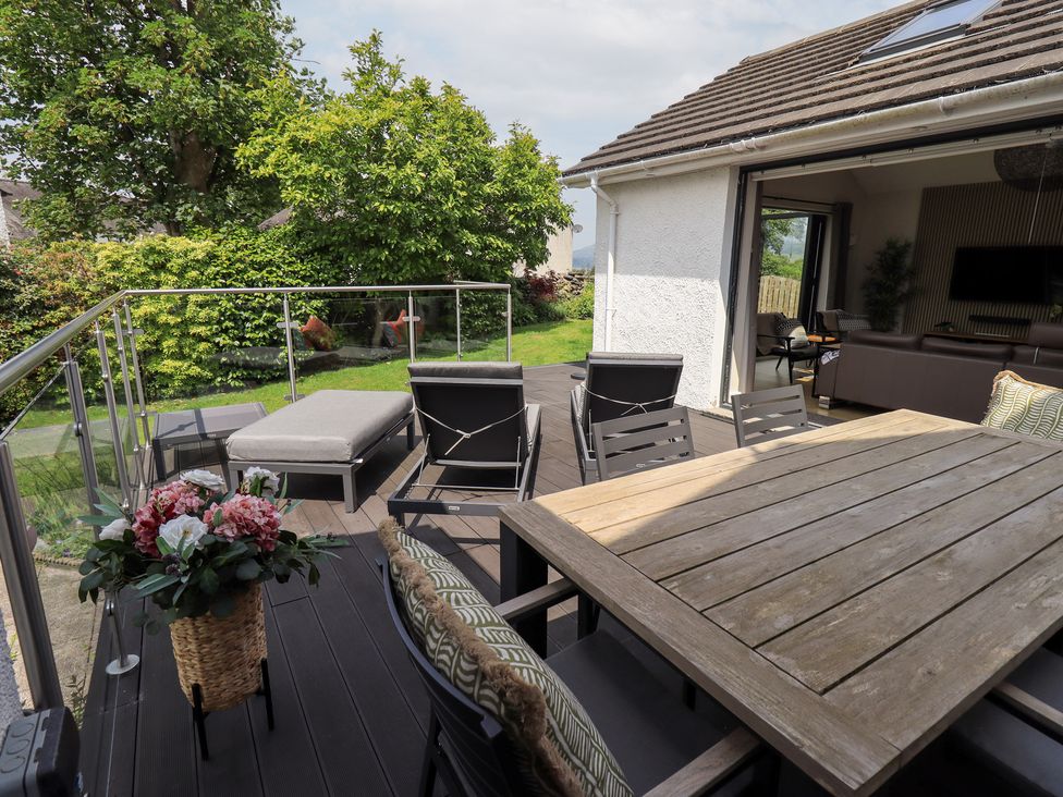 An outdoor patio with seating and a dining table at Yonder Lea in Bowness-On-Windermere