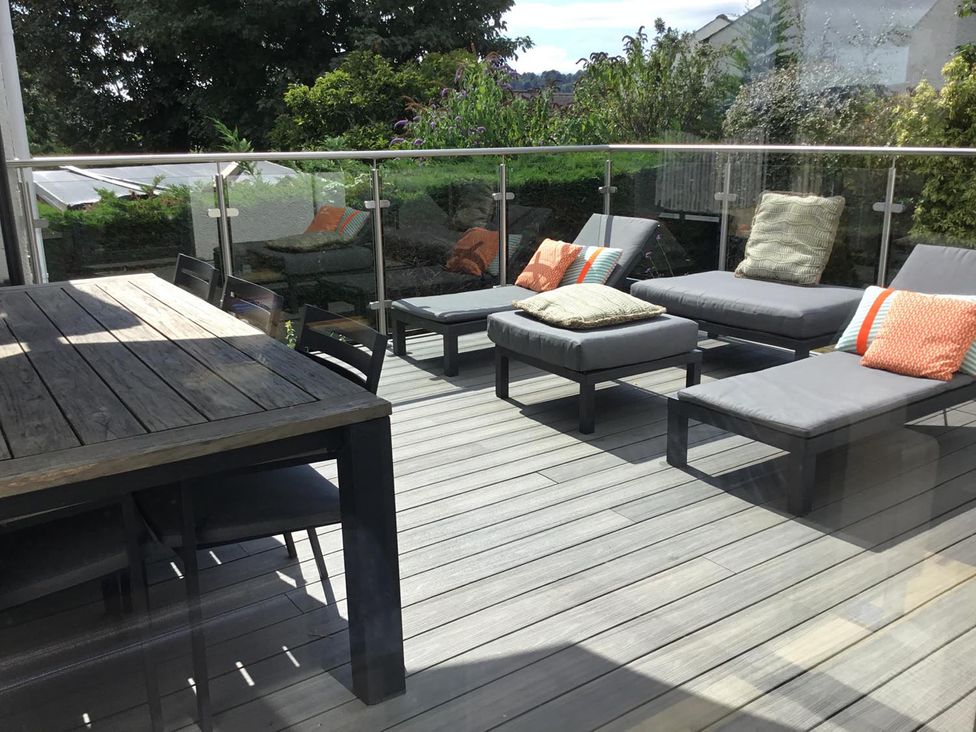 A deck with seating and table at Yonder Lea Bowness-On-Windermere