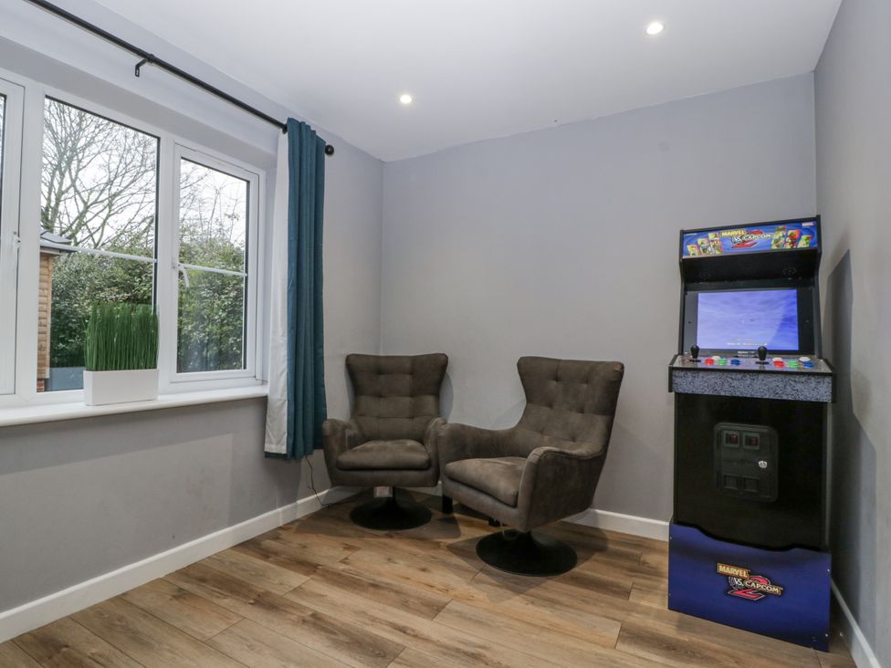 A game room with chairs and an arcade machine at Ranbir House in Longhope