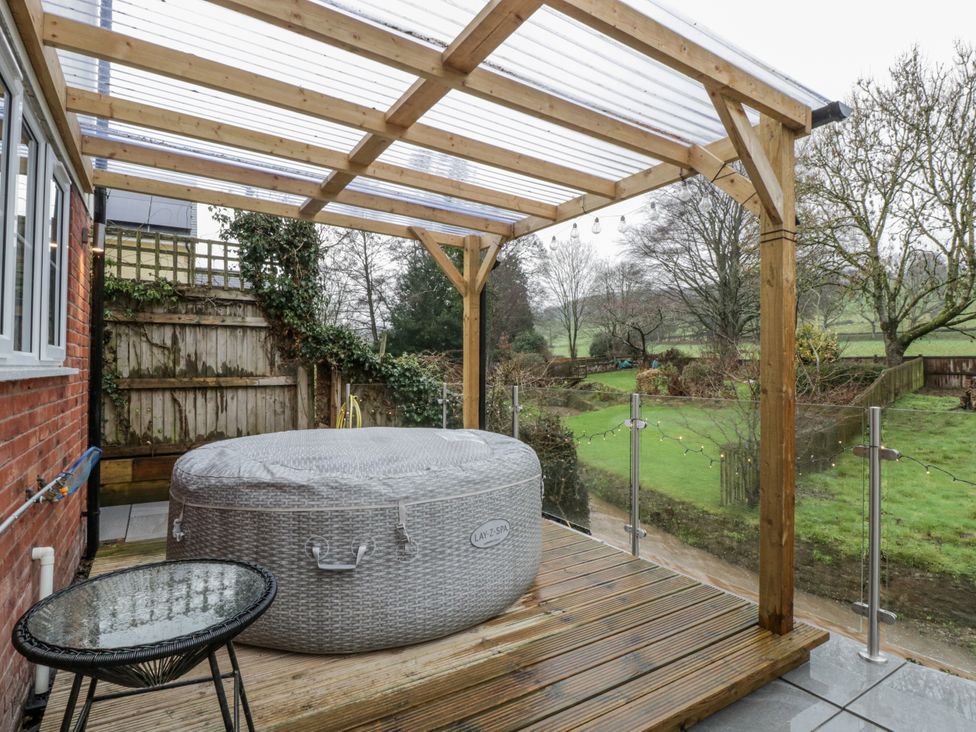 A garden with a hot tub and table at Ranbir House in Longhope