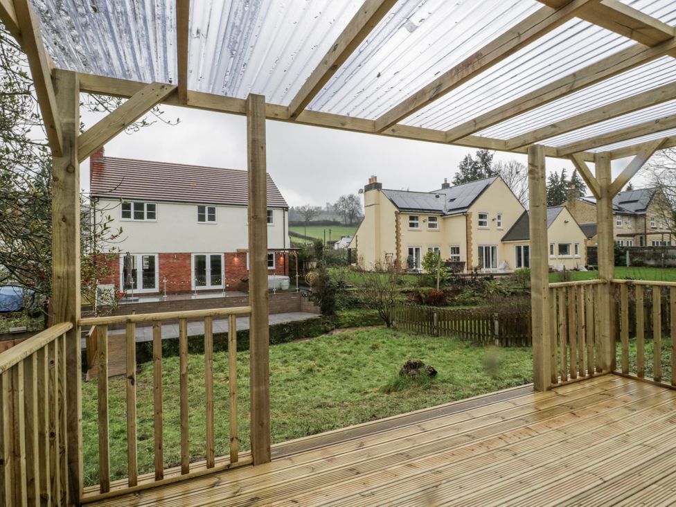 A view from a wooden deck looking at houses in the garden at Ranbir House Longhope