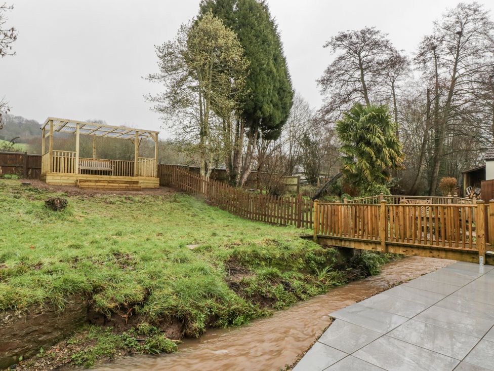 A garden with a wooden gazebo and a stream at Ranbir House Longhope