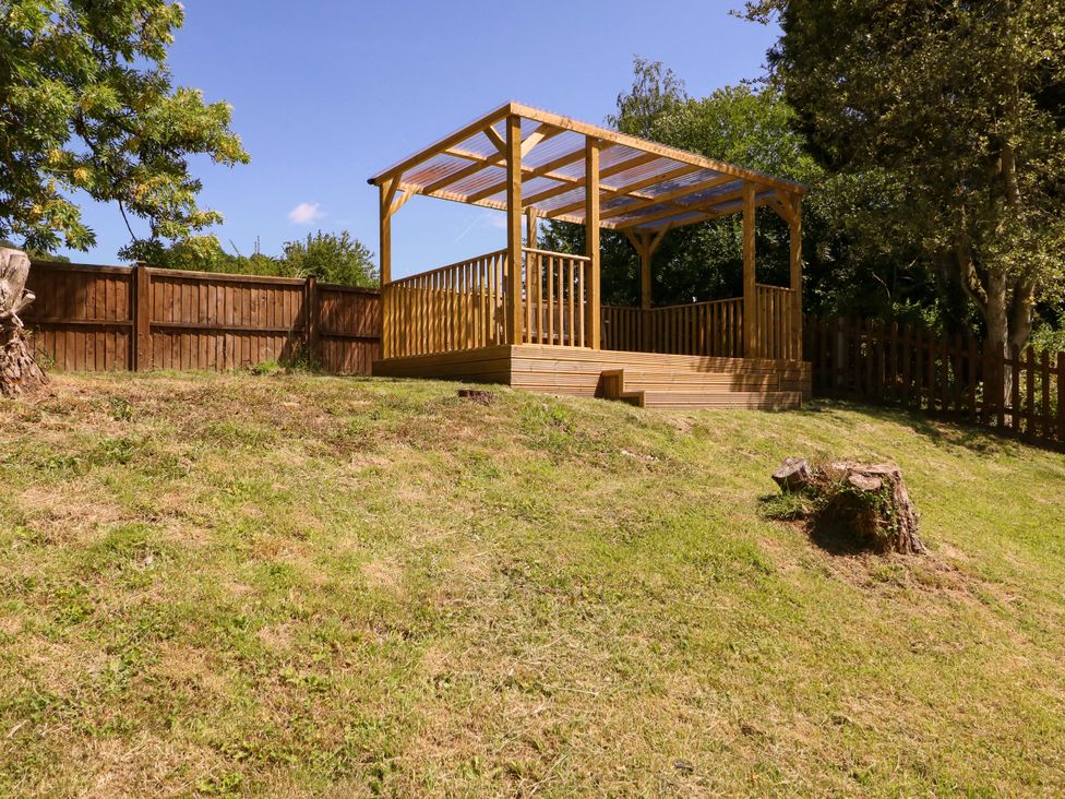 A garden with a wooden deck area at Ranbir House in Longhope