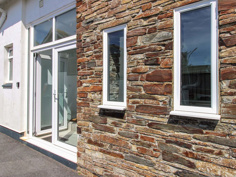 A stone wall with windows and a door at Tansea in Hope Cove