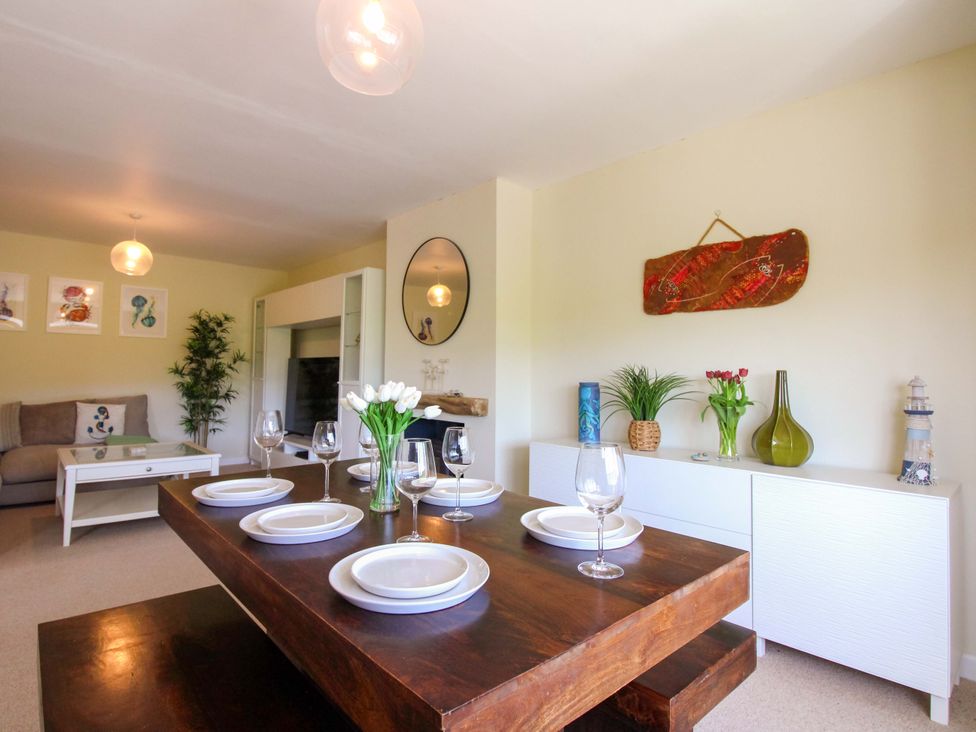 A dining area with a large table set at Tansea in Hope Cove
