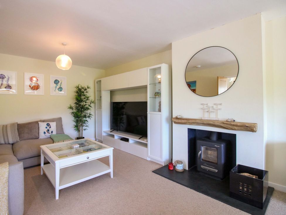 A living room with a sofa and television at Tansea in Hope Cove