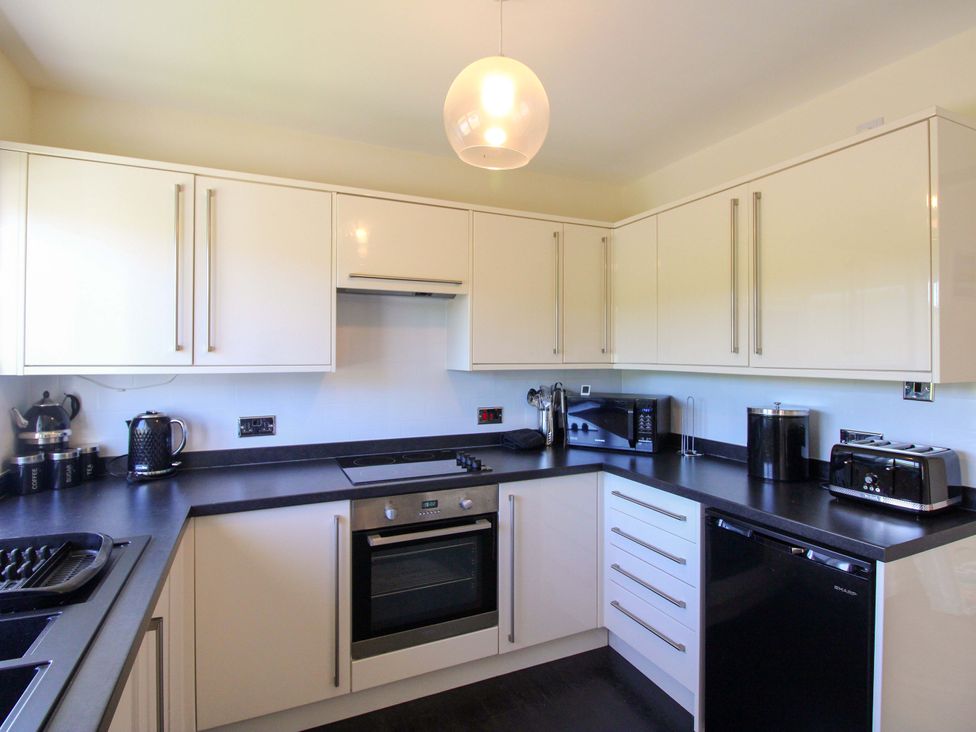 A kitchen with appliances and cabinets at Tansea Hope Cove