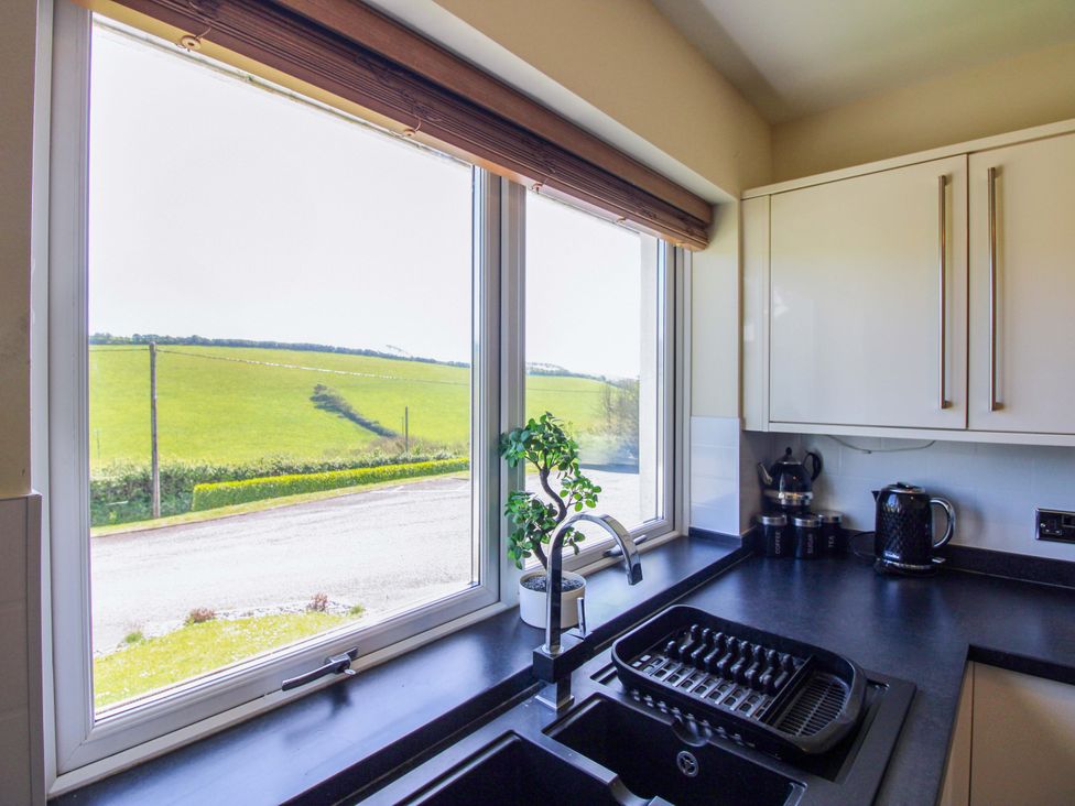 A kitchen with sink and window view at Tansea in Hope Cove