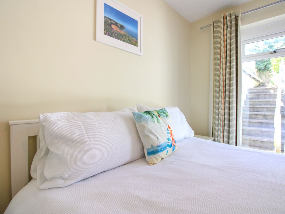 A bedroom with a bed and a window at Tansea in Hope Cove
