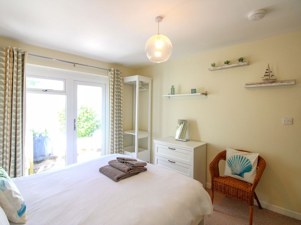 A bedroom with a bed and wardrobe at Tansea in Hope Cove