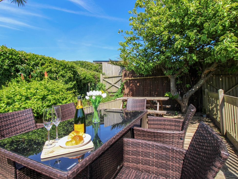 A garden with a dining table and chairs at Tansea in Hope Cove