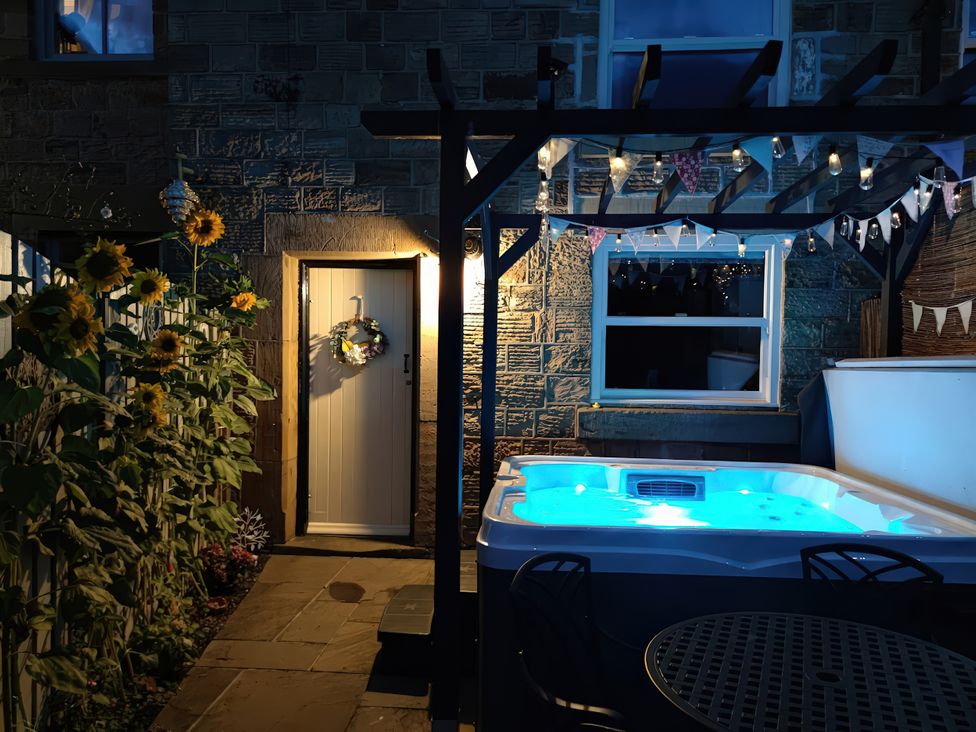 An outdoor space with a hot tub and sunflowers at Courthouse Cottage, Eckington, Derbyshire
