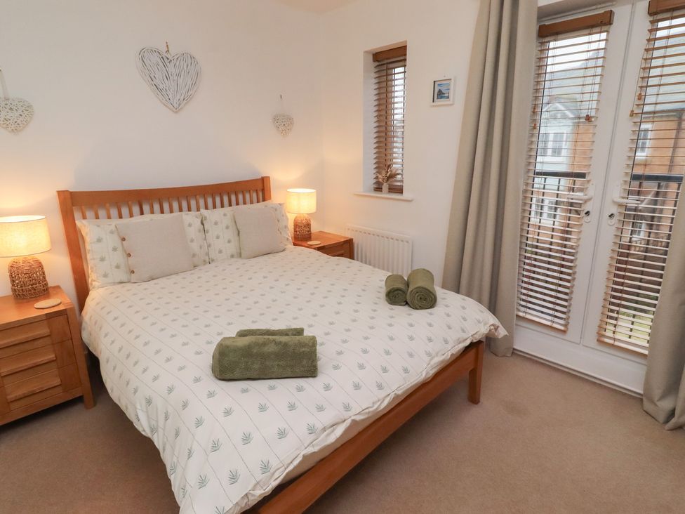 A bedroom with a bed and bedside tables at Brucap Cottage in Beadnell