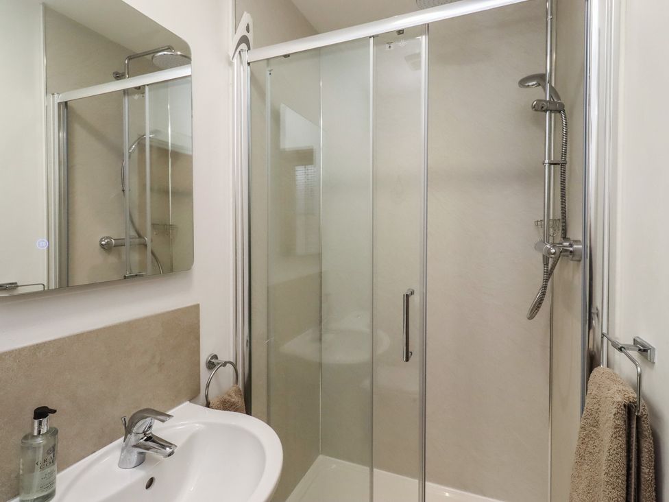 A bathroom with a shower and sink at Brucap Cottage Beadnell