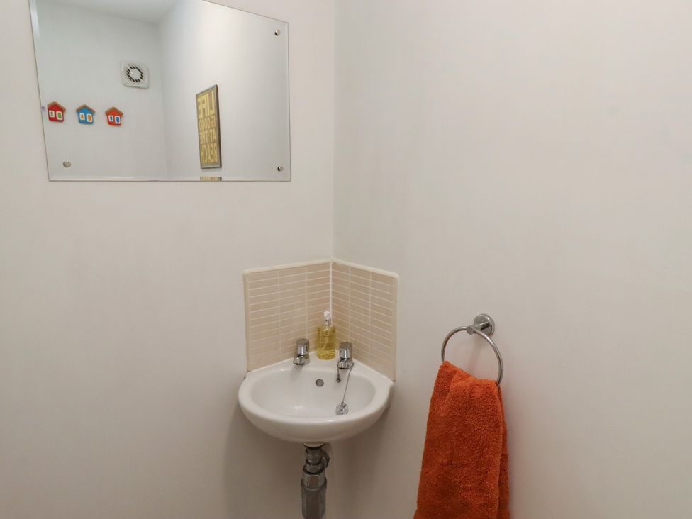 A bathroom with a sink, mirror, and towel at Brucap Cottage Beadnell