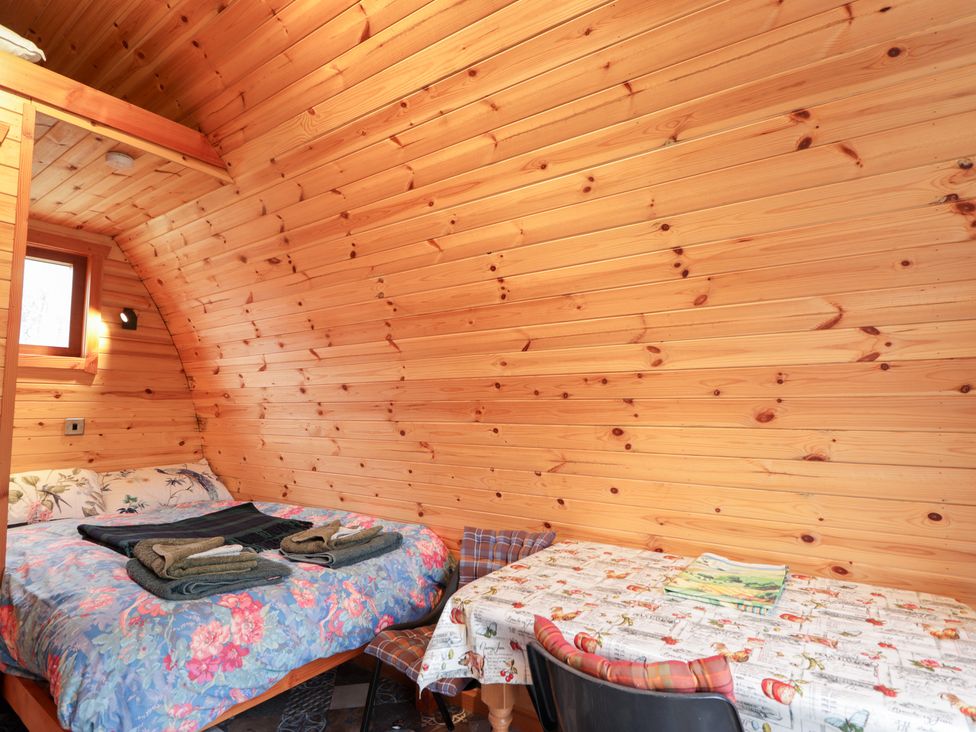 A bedroom with a bed and a table at Pod 1