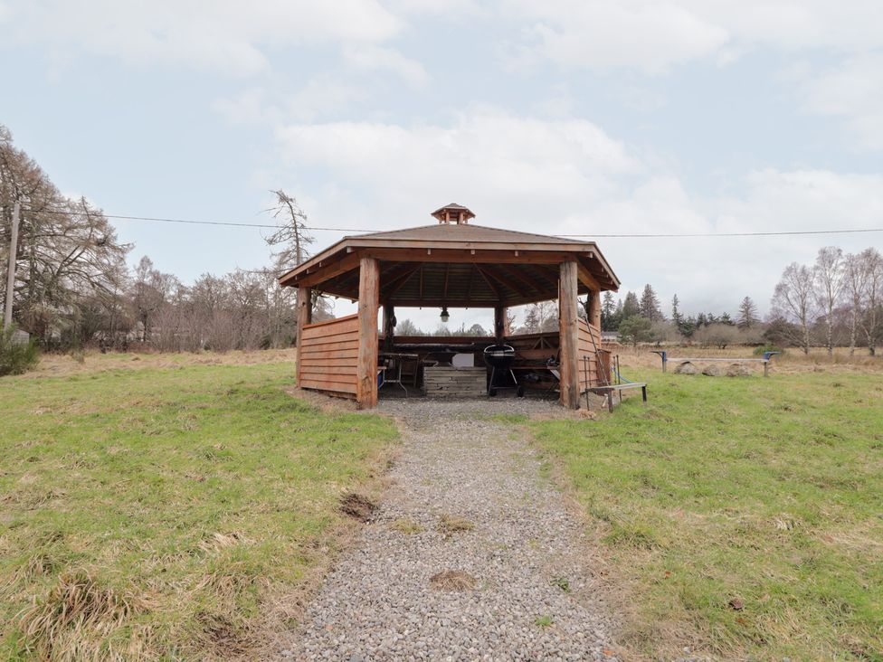 A gazebo with tables and benches at Pod 1