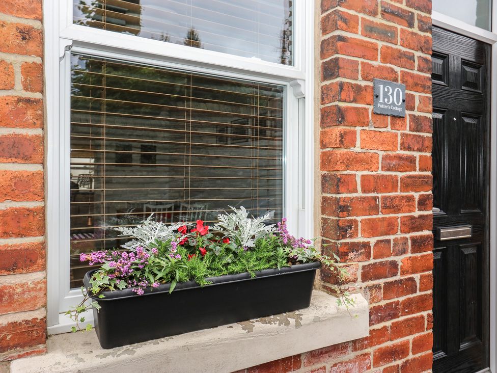 A window with a flower box and door at Potter’s Cottage Fulwood near Sheffield