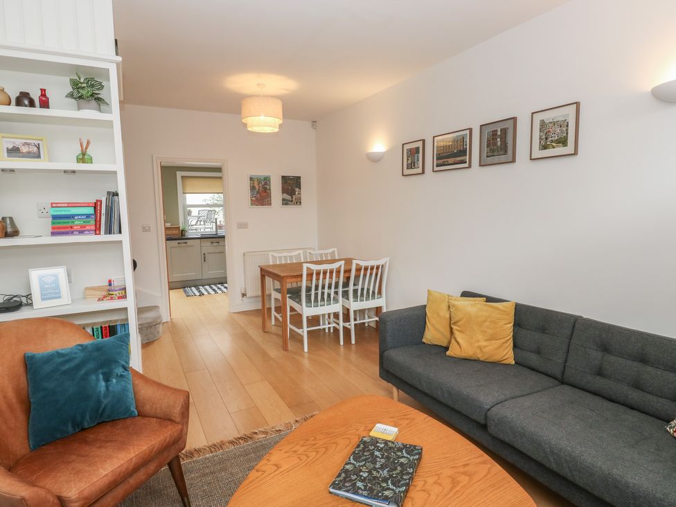 A living room with a sofa and dining area at Potter’s Cottage Fulwood near Sheffield