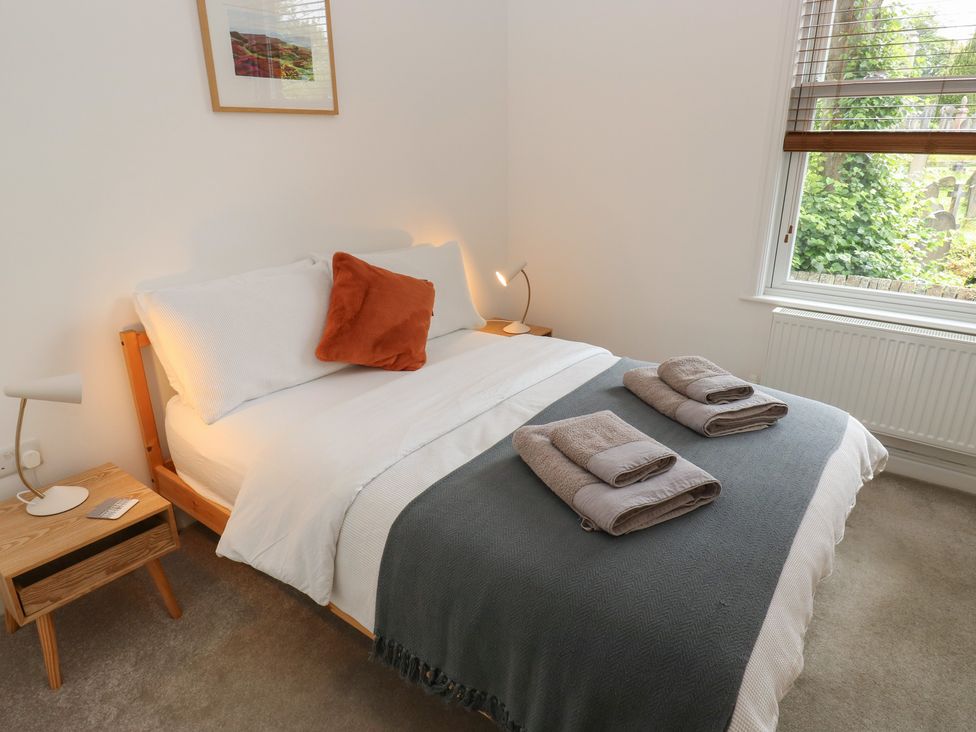 A bedroom with a bed and towels on the blanket at Potter’s Cottage Fulwood near Sheffield