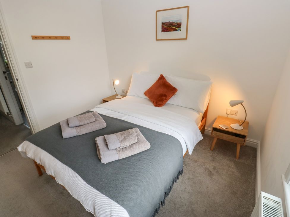 A bedroom with a bed and nightstand at Potter’s Cottage in Fulwood near Sheffield