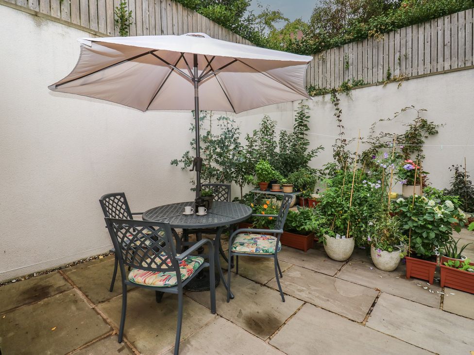 A table and chairs with an umbrella in a garden at Potter’s Cottage Fulwood near Sheffield