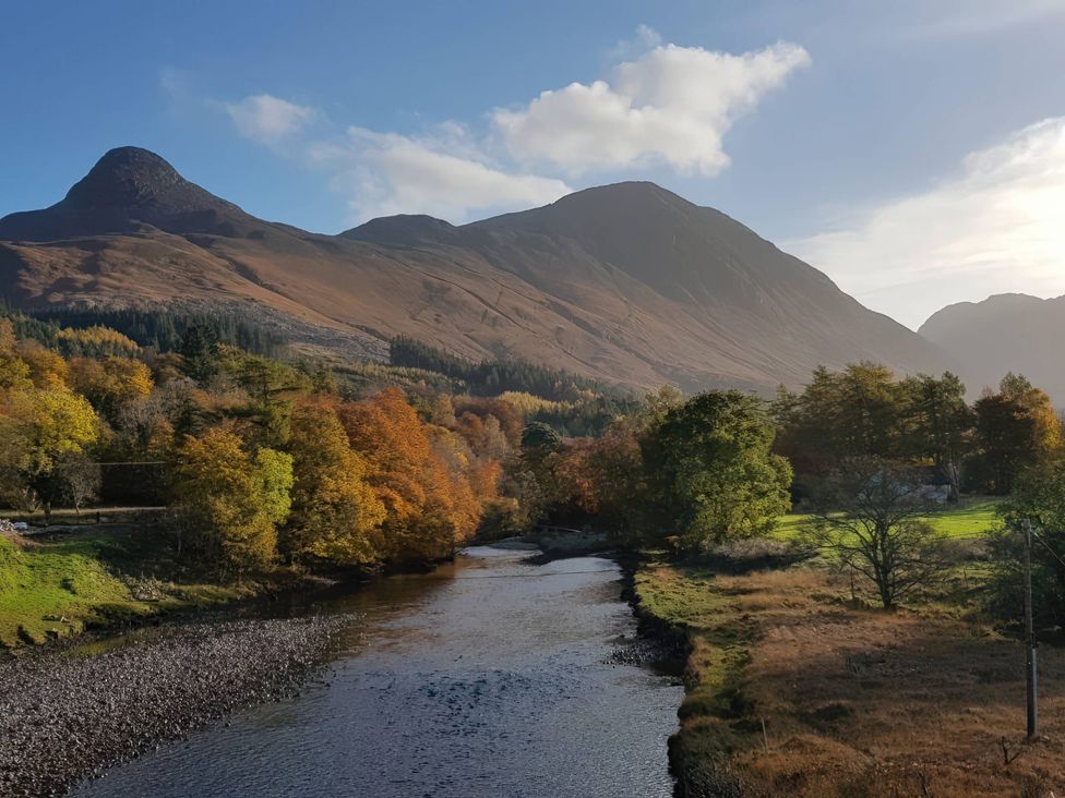 A landscape view with mountains, a river, and trees at Callart View in Glencoe