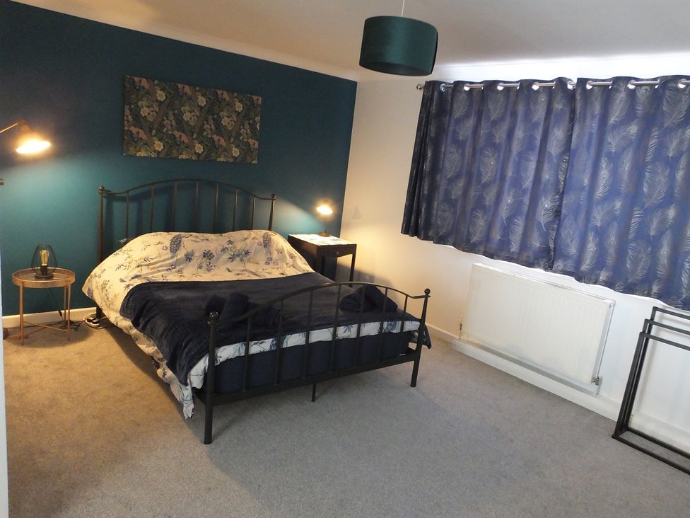 A bedroom with a bed and bedside table at 1 Ilsham Cottages in Torquay