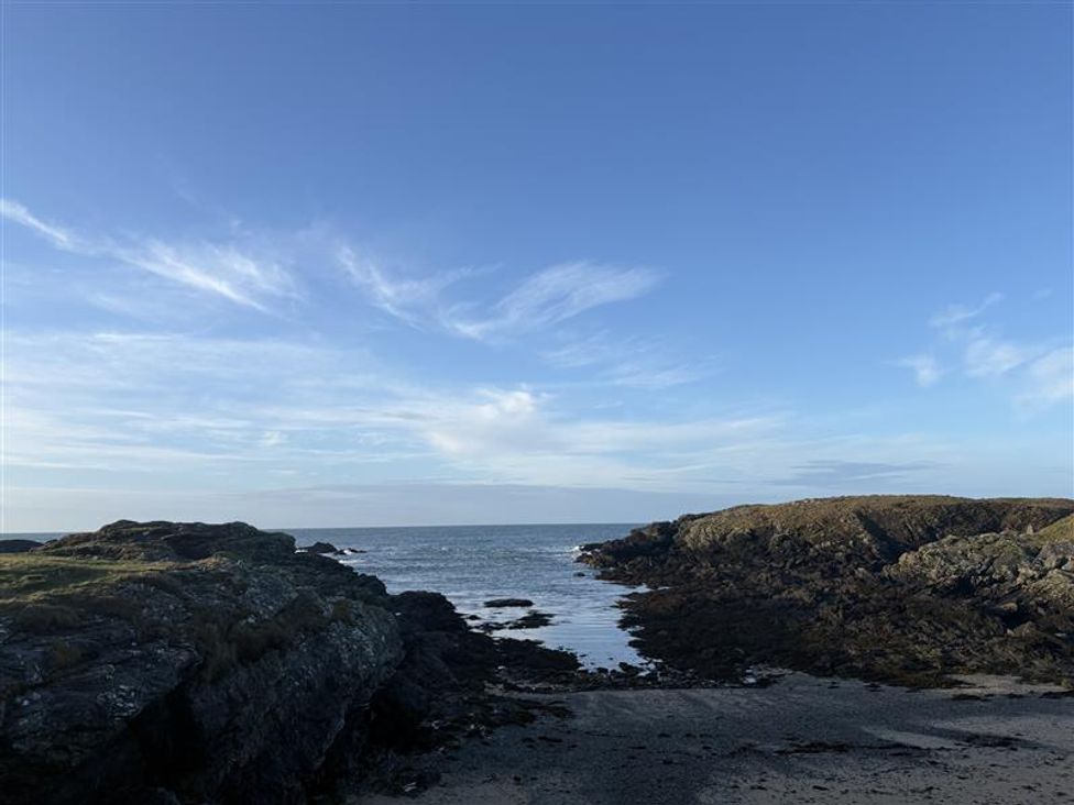 A view of the ocean with rocks and sandy area at Seaside Sanctuary in Trearddur Bay