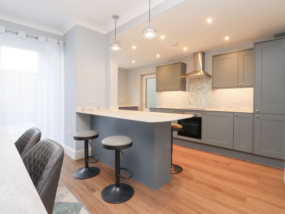 A kitchen with bar stools and countertop at 480 Marine Road East in Morecambe