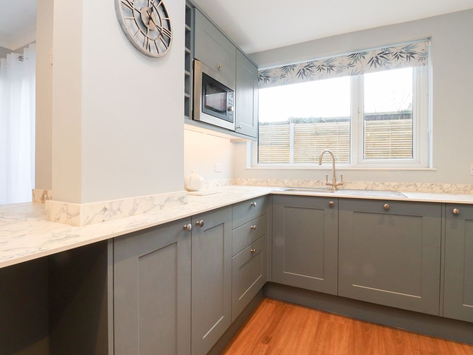 A kitchen with a sink and microwave at 480 Marine Road East in Morecambe