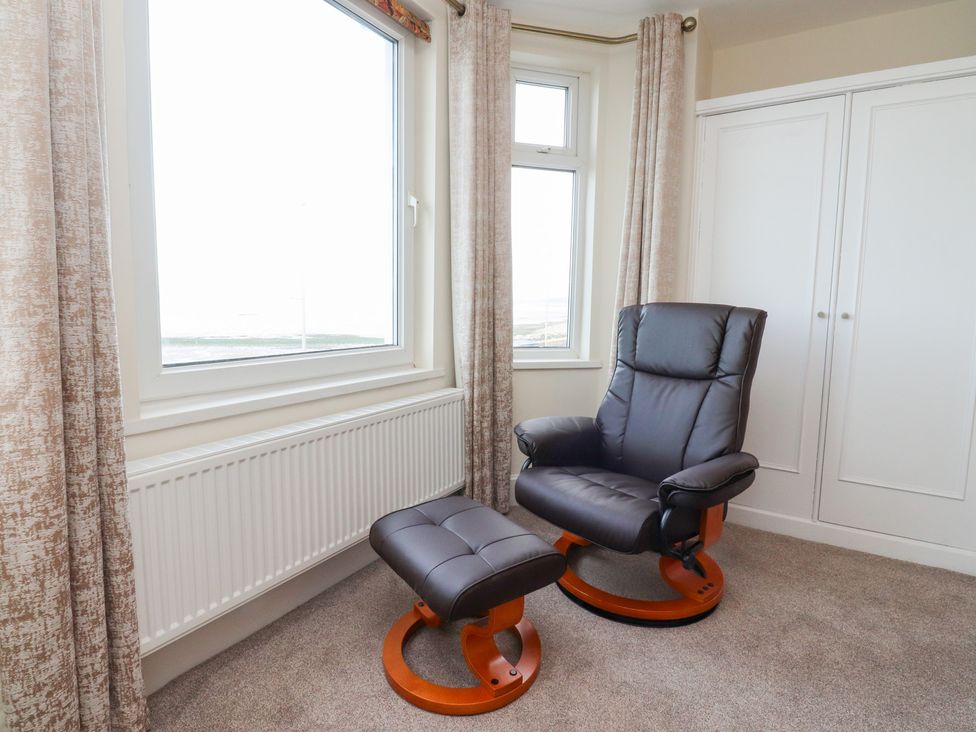 A sitting room with a chair and footstool at 480 Marine Road East in Morecambe