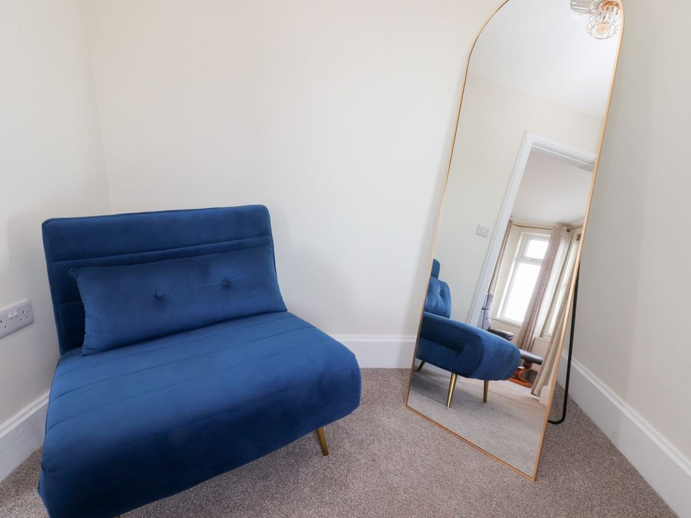 A chair and mirror in a bedroom at 480 Marine Road East Morecambe