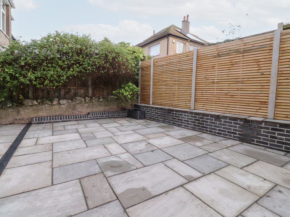 A garden with paved patio slabs and a wooden fence at 480 Marine Road East Morecambe