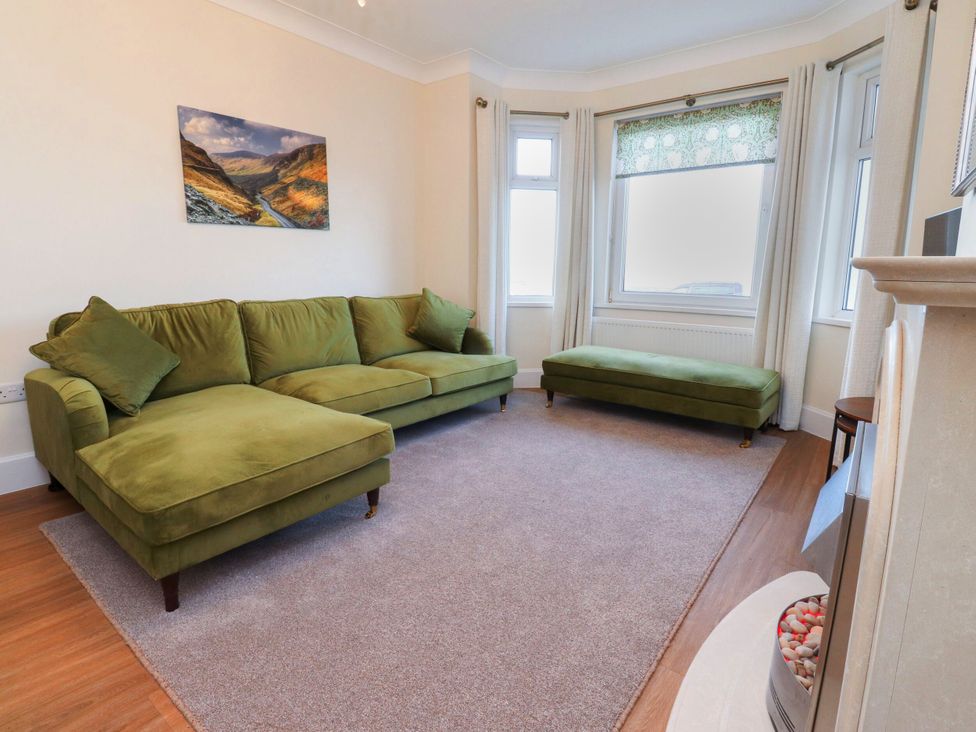 A living room with a green sofa and chaise lounge at Marilyn in Morecambe