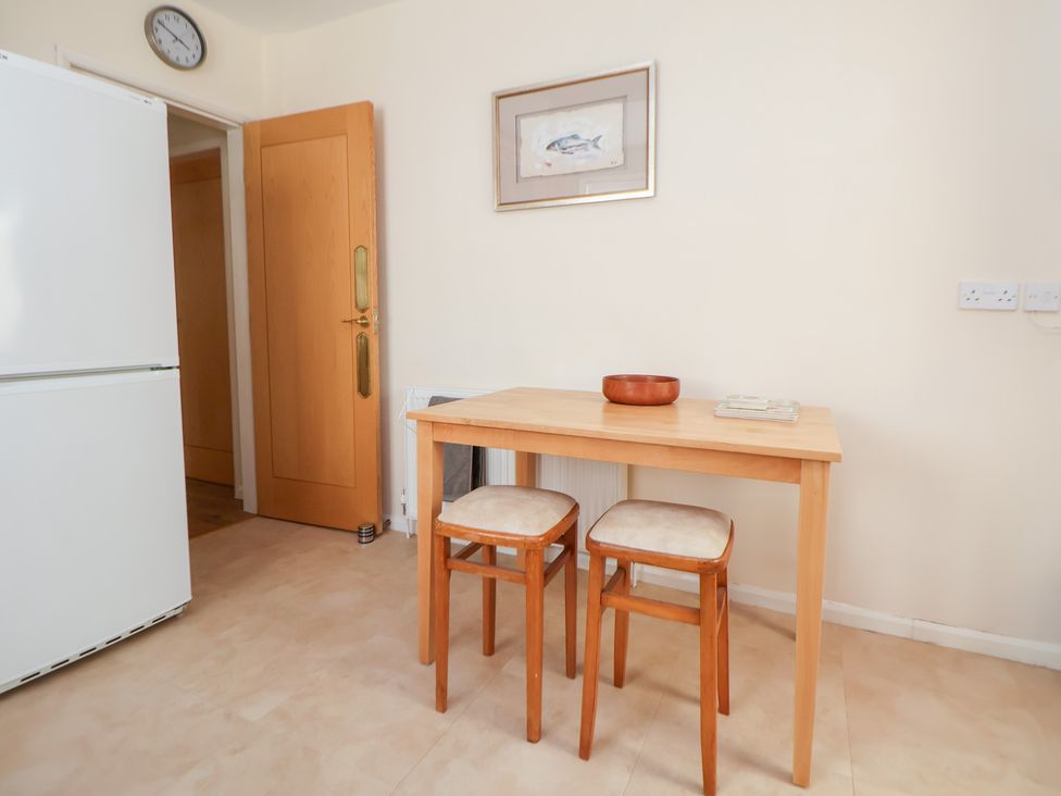 A dining room with a table and chairs at Bryn Bach in Rhos-On-Sea