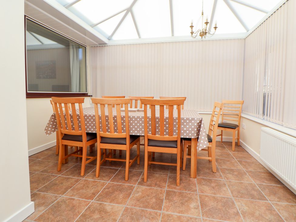 A dining room with a table and chairs at Bryn Bach in Rhos-On-Sea